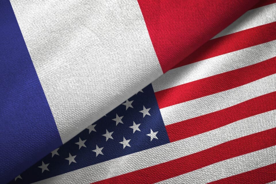 The flags of France and the United States overlapping, symbolizing relations between the two nations
